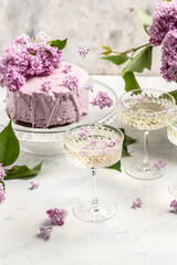 Obraz na płótnie Canvas prosecco, champagne, wine and blueberry tart with bouquet of purple blooming lilacs, postcard, background. vertical image place for text