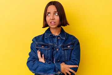 Young mixed race woman isolated on yellow background dreaming of achieving goals and purposes