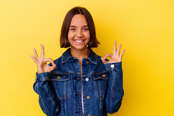 Young mixed race woman isolated on yellow background cheerful and confident showing ok gesture.