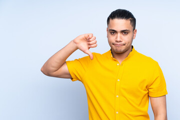 Asian handsome man over isolated background showing thumb down with negative expression