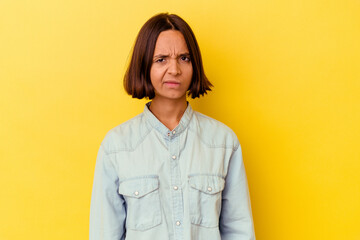 Young mixed race woman isolated on yellow background sad, serious face, feeling miserable and...