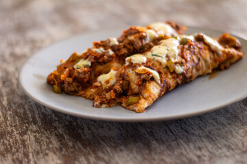 Homemade cannelloni with freshly cooked sauce. Rustic table with fresh food.