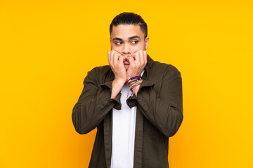 Asian handsome man isolated on yellow background having doubts and thinking