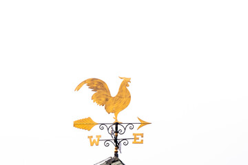 Gold rooster weather vane show the wind direction on white sky background