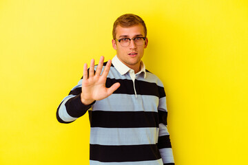 Young caucasian man isolated on yellow background