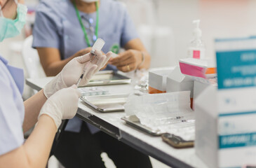 Nurse wearing medical mask preparing coronavirus vaccine to vaccinate
