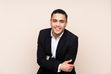Asian business man isolated on beige background laughing