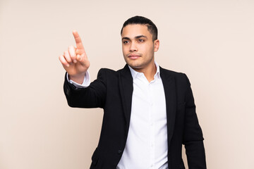 Asian business man isolated on beige background touching on transparent screen
