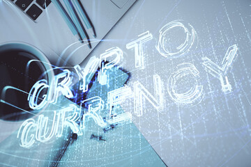 Blockchain theme hologram drawings over computer on the desktop background. Top view. Multi exposure. Concept of cryptoeconomy.