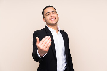 Asian business man isolated on beige background inviting to come