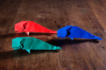 Origami whaleS over wooden background. Conceptual image.
