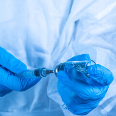 covid-19 sars-cov-2 vaccination: a health worker with a vaccine and a syringe in his hands