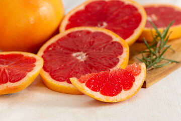 Fototapeta na wymiar Ripe grapefruit and slice grapefruit put on wooden tray hand made cloth background.