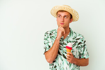 Fototapeta premium Young caucasian man wearing a summer clothes and holding a ice cream isolated on white background