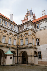 Obraz premium Gothic Castle Brandys nad Labem, Renaissance palace, clock tower, Historical Courtyard with sgraffito mural decorated plaster at facade, wall decor, Central Bohemian, Czech Republic