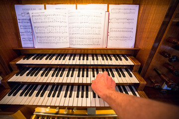 Stockholm, Sweden An organ inside the Uppenbarelse Church in Hagersten and a hand on the keyboard.
