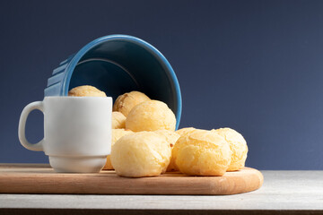 Cheese bread (pão de queijo) with coffee on blue background.