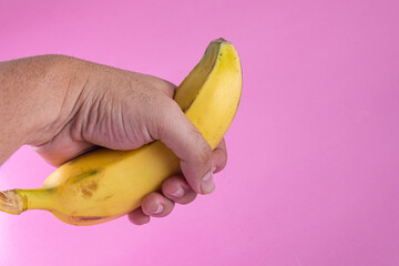 Banana on the pink background - man holding