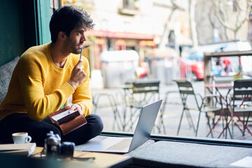 Thoughtful ethnic man writing notes