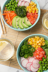 Delicious salad with salmon and vegetables served on white marble table, flat lay