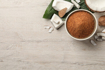 Flat lay composition with natural coconut sugar on white wooden table, space for text