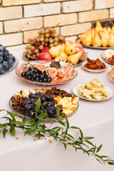 Grapes, pears, dried fruits and other food on decorated table.