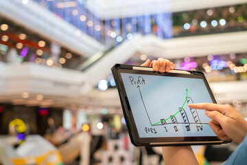 A manager using tablet to see business growth predictation graph of 2021 on screen with blur...