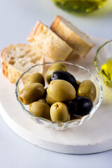 Bowls with Green and Black Olive Olive Oil on White Tray Artisan Bread Mediterranean Food Blue Background Above