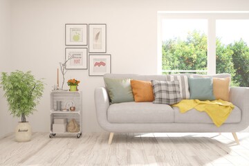 White living room with sofa and summer landscape in window. Scandinavian interior design. 3D illustration