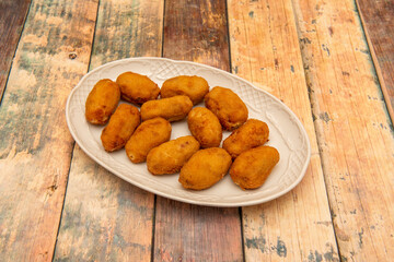 white porcelain tray with a generous portion of assorted croquettes of serrano ham and cod
