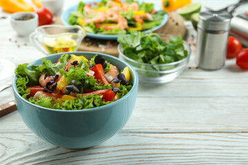 Concept of tasty eating with shrimp salad on white wooden table