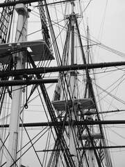 Monochromatic image of a bunch of tall masts.