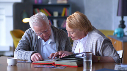 Seniors looking at their photo album at home
