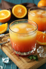 Tequila Sunrise cocktails and ingredients on wooden table