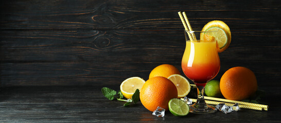 Tequila sunrise cocktail and ingredients on wooden table