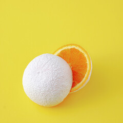 Surreal idea of unreal white cut orange fruit on yellow background.