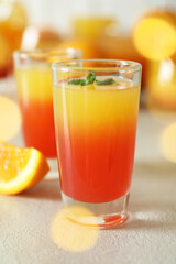 Tequila sunrise cocktails on white textured table, close up