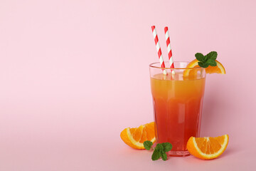 Tequila sunrise cocktail and ingredients on pink background