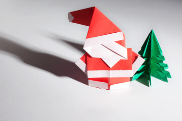 Origami santa claus with red and green trees isolated on white background.