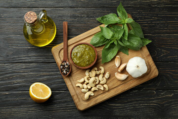 Pesto sauce and ingredients for cooking on wooden background