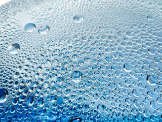 An abstraction. Drops of water, dew, on the blue glass.