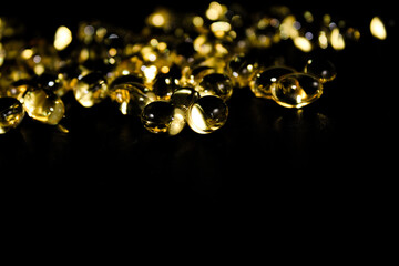 Cod liver oil capsules close up, abstract, isolated on black background