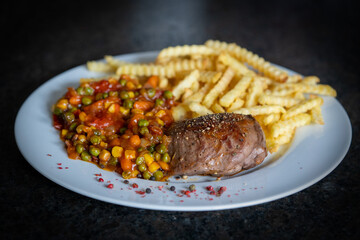 roasted venison steak with fries and spicy vegetables, mexican cuisine
