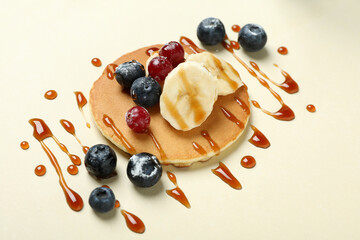 Concept of tasty food with pancake on beige background