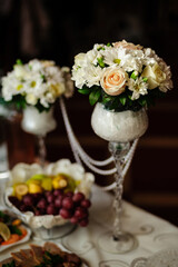 Сatering table with food, flowers and glass stemware at restaurant before party 