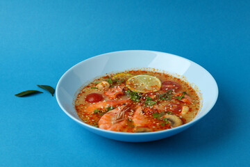 Tasty Tom yum soup on blue background