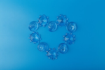 Creative flat lay with heart made of different sea shells on blue background. Concept of summer vacations by sea or ocean 