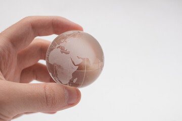 Glass crystal globe ball in hand on white background.