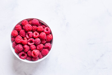 fresh raspberries in a round plate close-up.