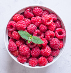 fresh raspberries in a round plate close-up.